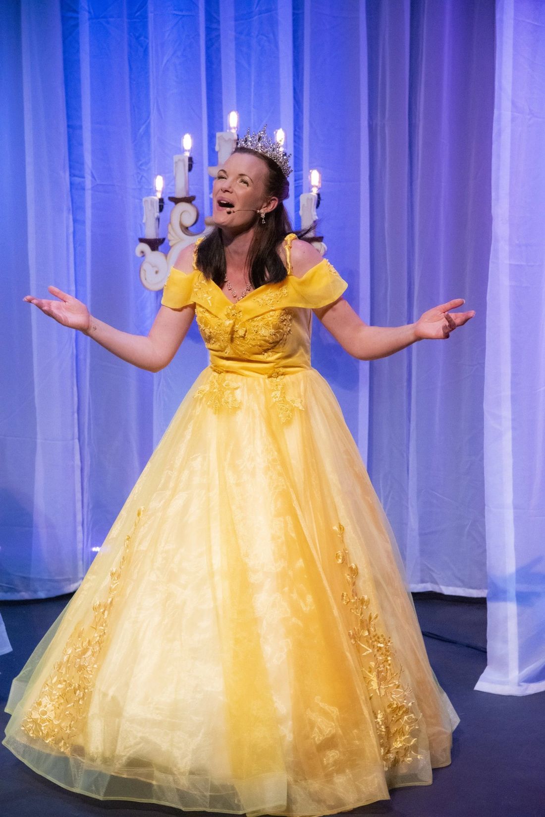 Belle in her gold gown on stage in Princesses Unite!
