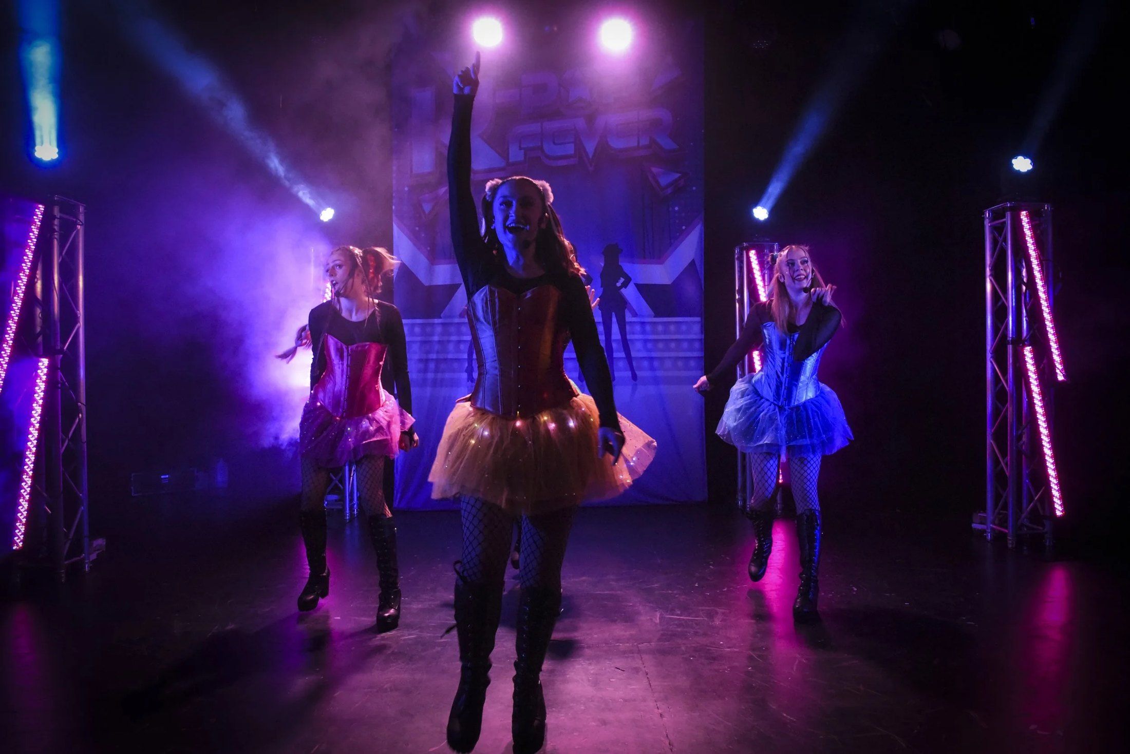 K-Pop Fever performers under purple stage lights